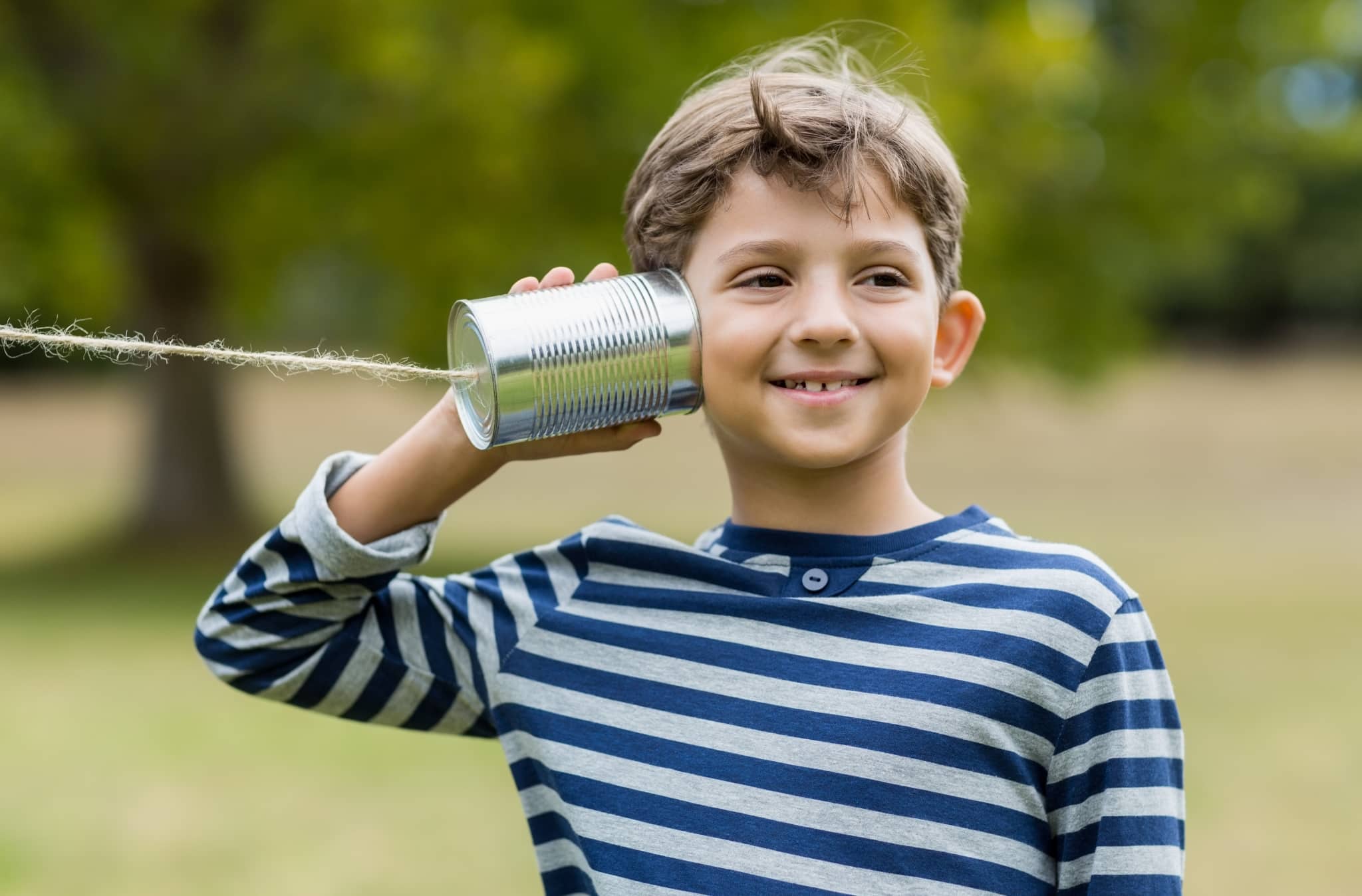 Boy listening through tin can phone