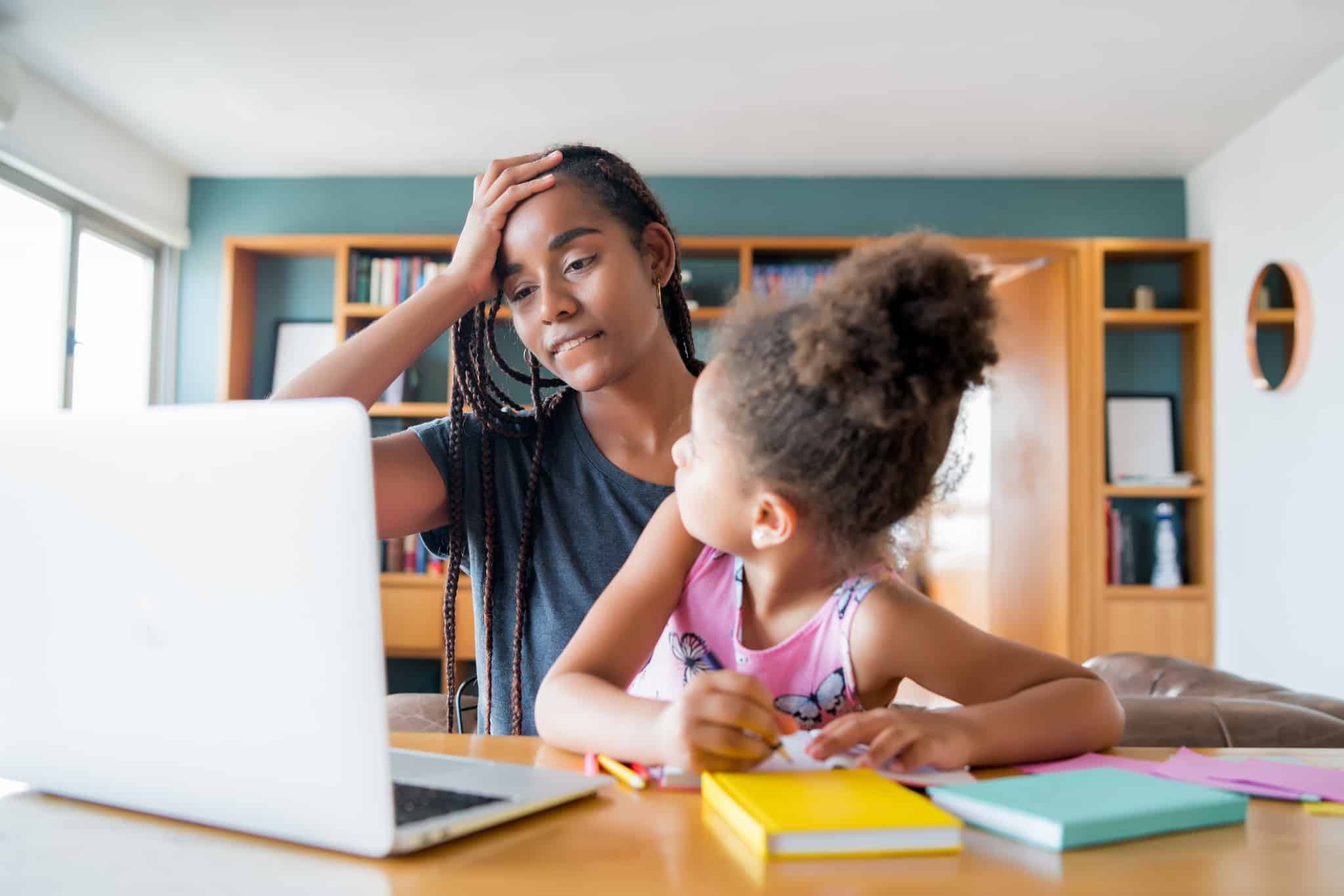 A mother helping her daughter with homeschool.