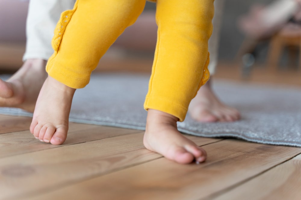 baby-learning-how-walk-being-helped-by-his-mother